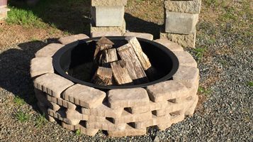 chitwood-dirt-yard-firepit Chitwood Dirt Yard | Rock Hill, SC | concrete blocks formed in a circle for a fire pit with wood in the center