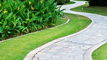 chitwood dirtChitwood Dirt Yard | Rock Hill, SC | stone path along a manicured, green lawn with nice landscaping with yellow flowers