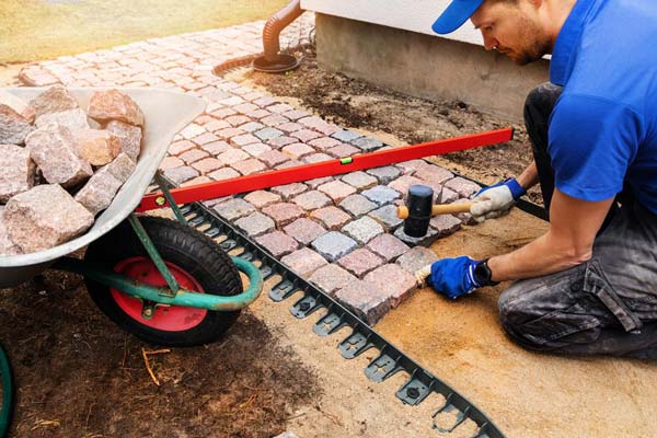 Chitwood Dirt Yard | Rock Hill, SC | worker laying down stone pavers along a new walkway